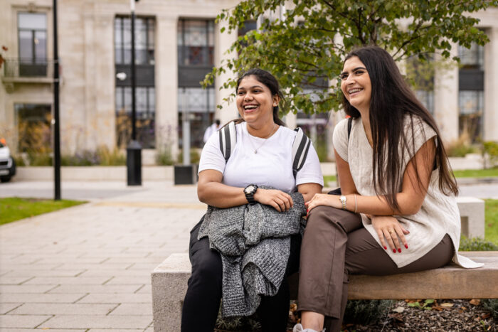 Two students sitting together, laughing