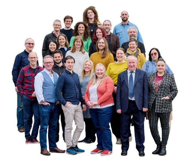 The diverse team of IDEA teaching staff standing together and smiling with a transparent background